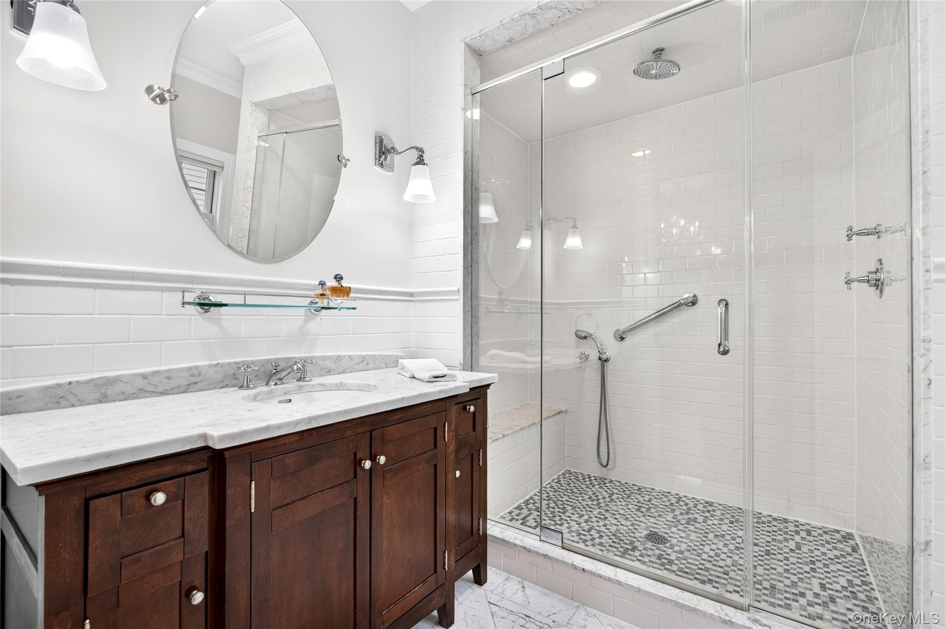Shower with frameless glass enclosure, rain showerhead, and subway tile surround