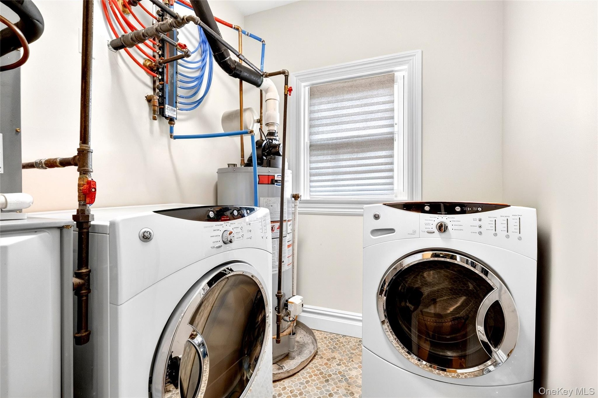 Laundry area with tile flooring and a window