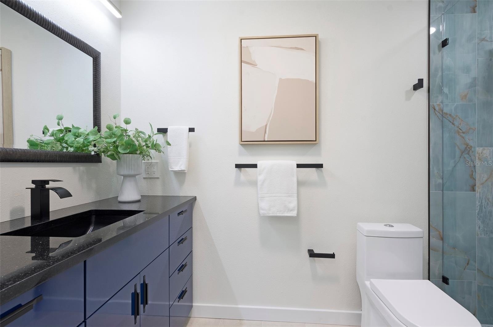 The Primary bathroom is functional and features designer touches. A tube skylight brings in natural light.