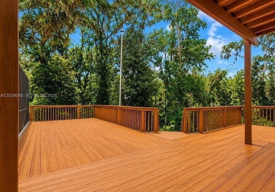 Comfortable exterior deck space offering a quiet retreat with views of the expansive acreage.
