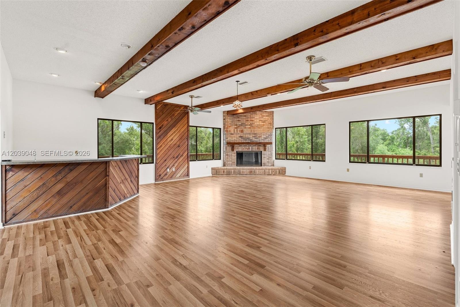 Inviting living space featuring a fireplace framed by a warm wood accent wall and a built-in bar area, creating an ideal setting for relaxing and ente