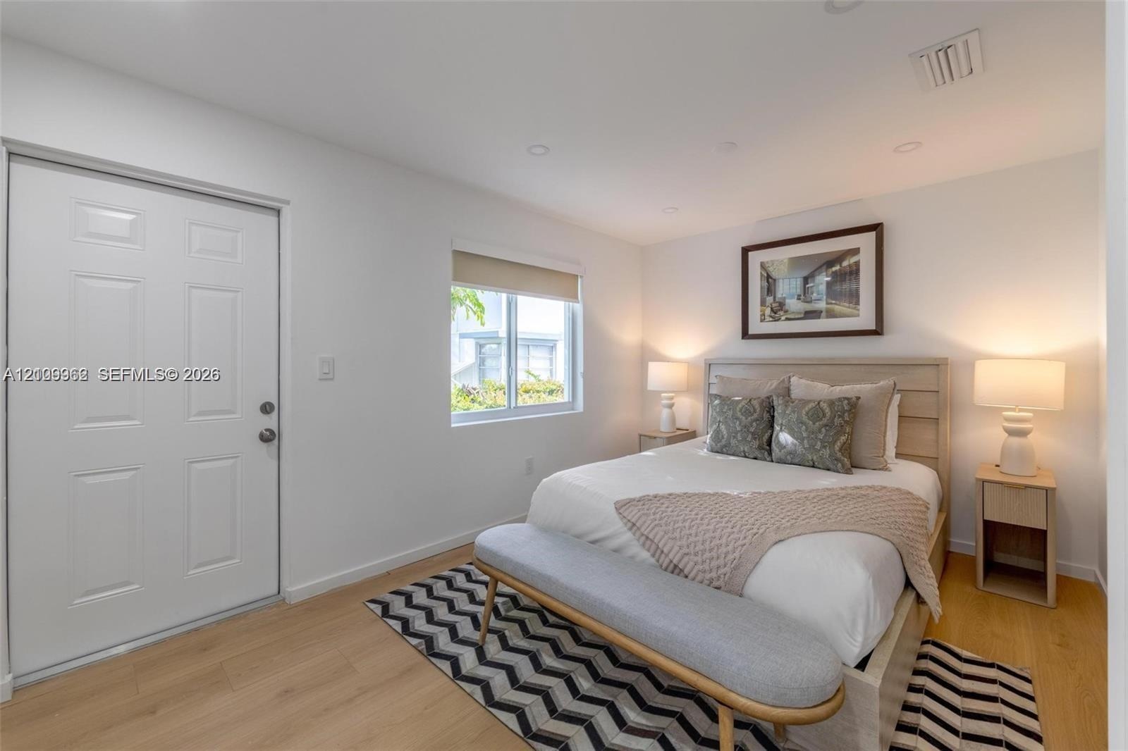 Neutral-toned interior featuring wood-finish flooring, recessed lighting, and a single-panel interior door