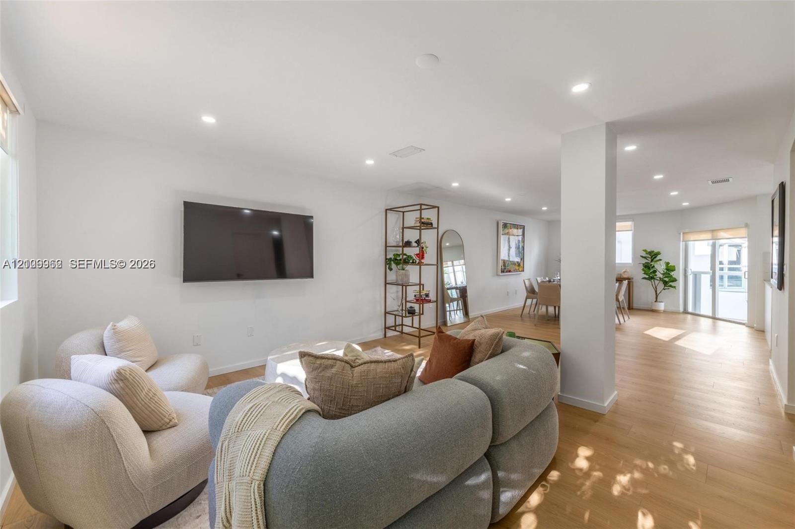 Open-concept interior featuring wood-finish flooring, recessed lighting, and expansive wall space