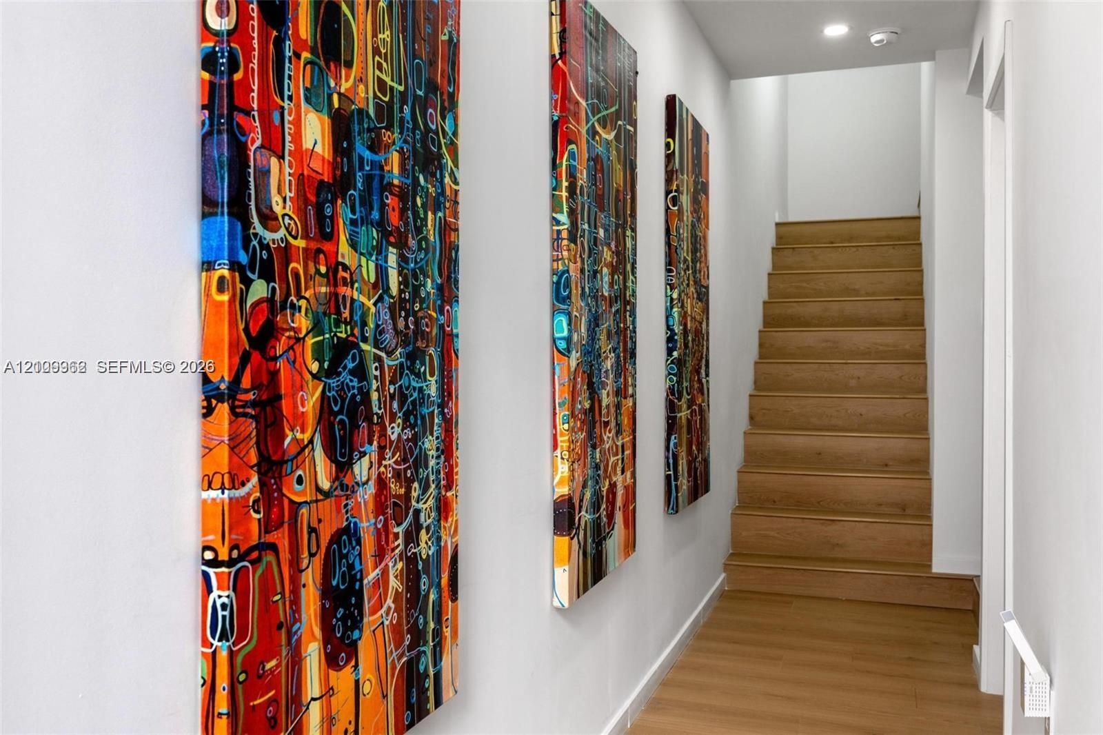 Staircase featuring wood-finish treads and recessed ceiling lighting