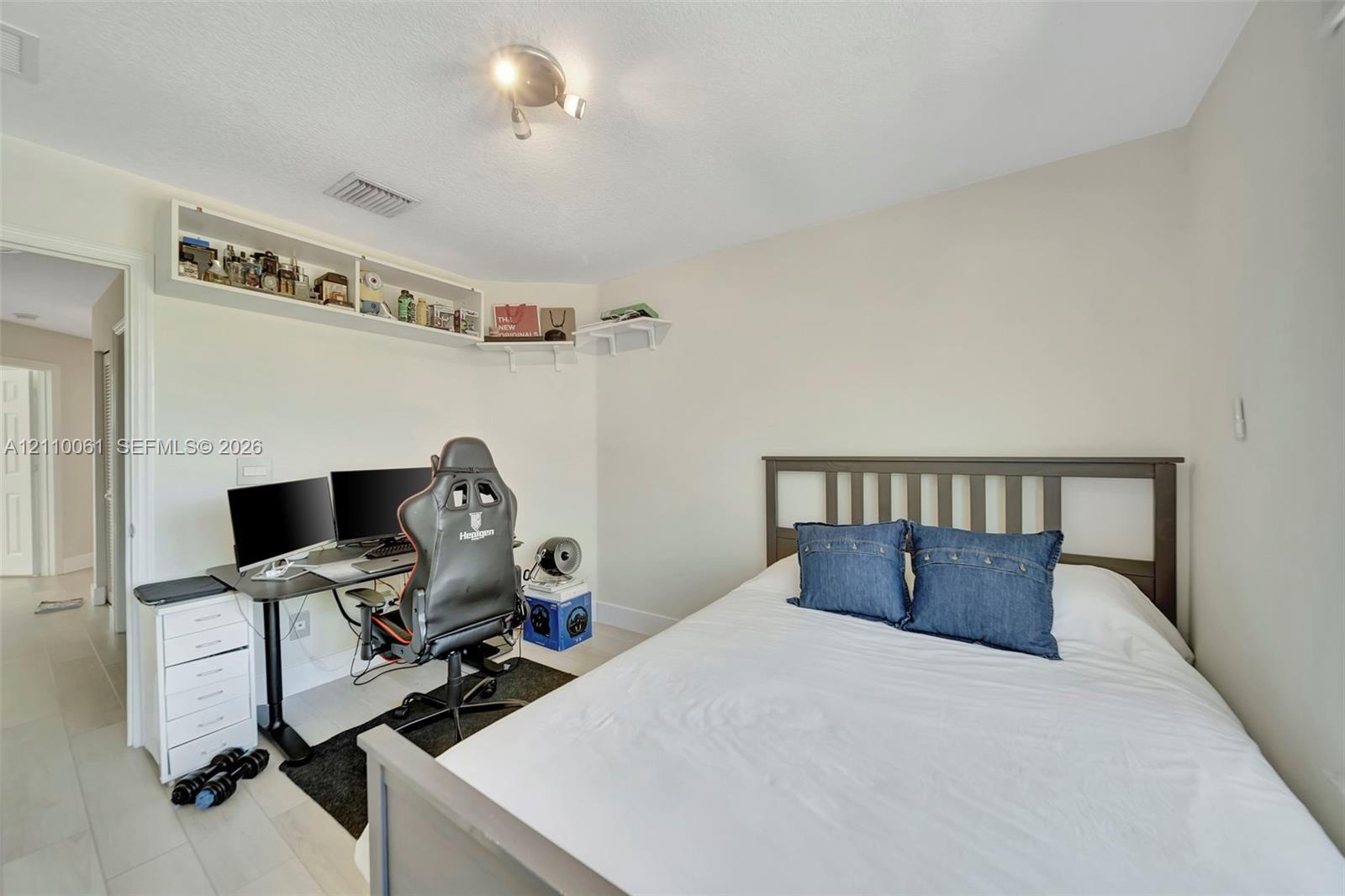Neutral-toned room featuring light-colored flooring and built-in white corner shelving