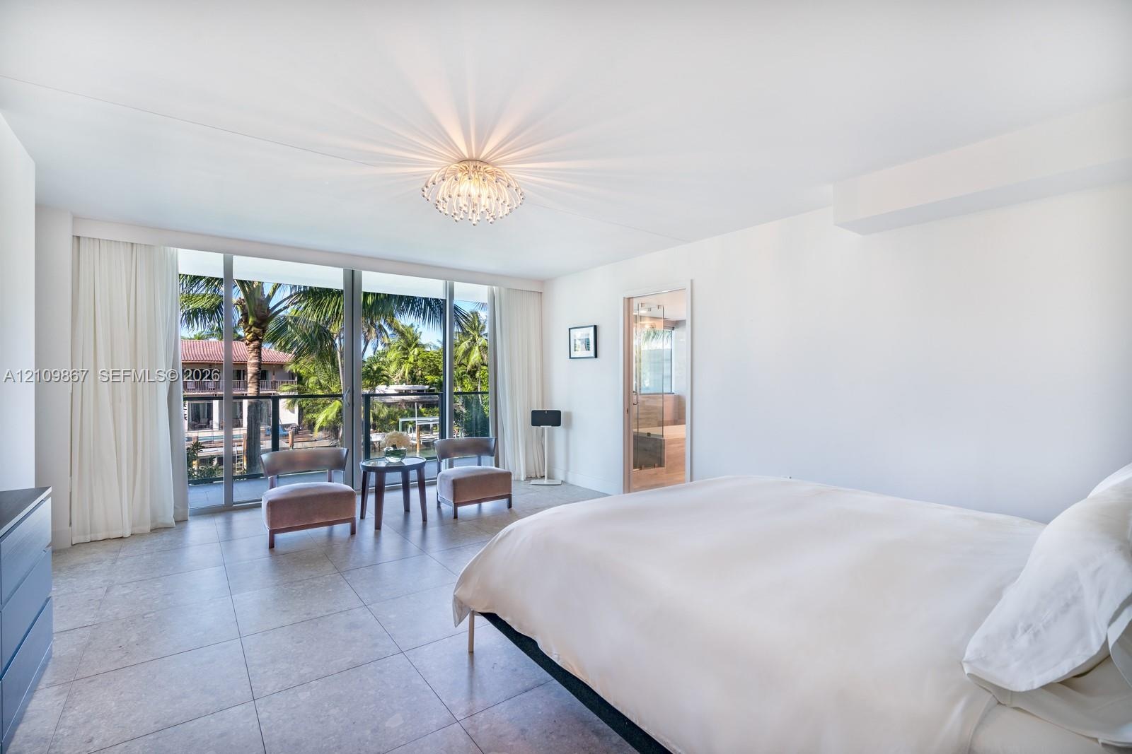 Full-height sliding glass doors with black metal framing, large-format tile flooring, recessed ceiling fixture, and glass-paneled interior door