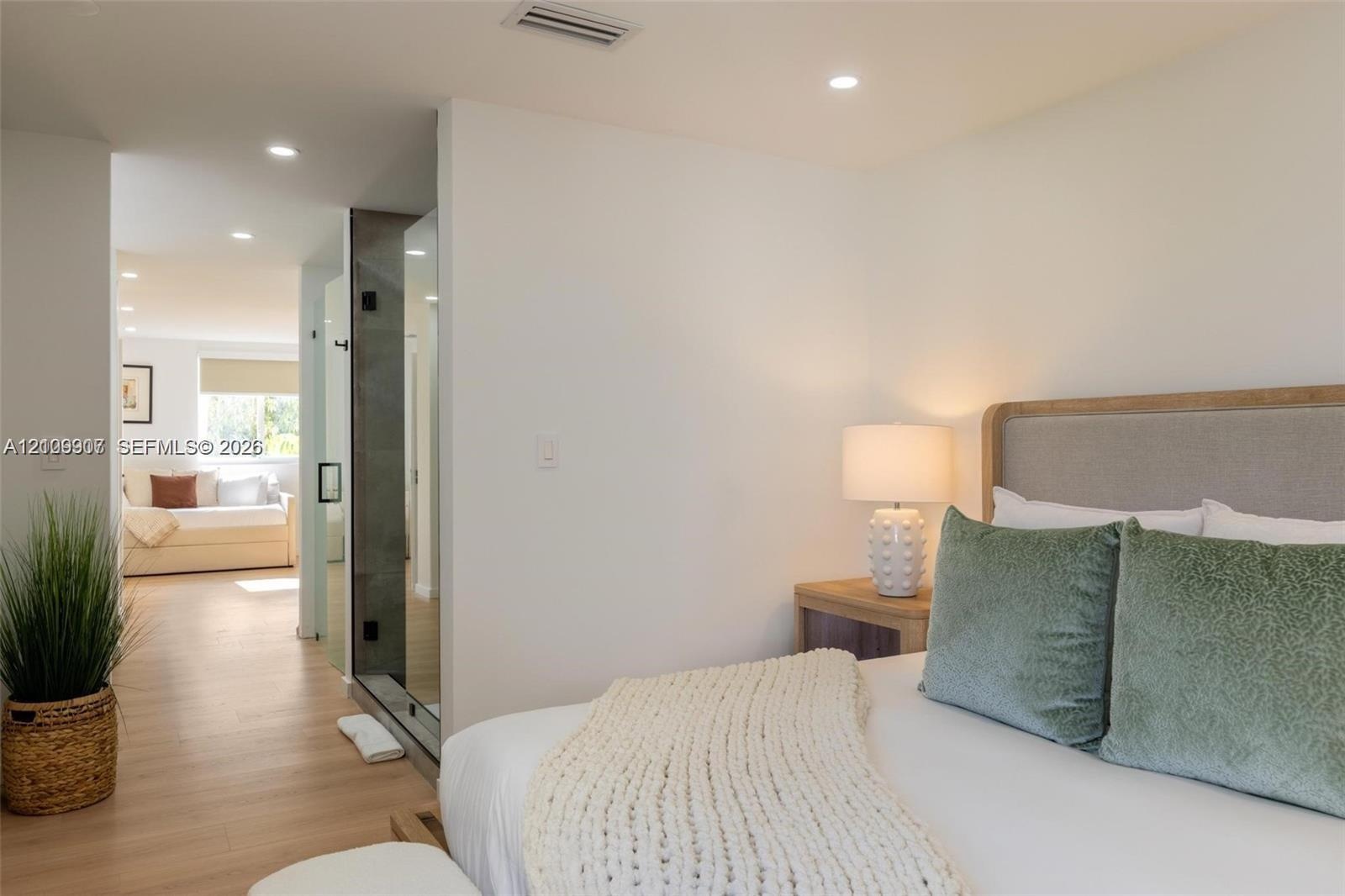 Recessed lighting, wood-finish flooring, and glass-enclosed shower stall