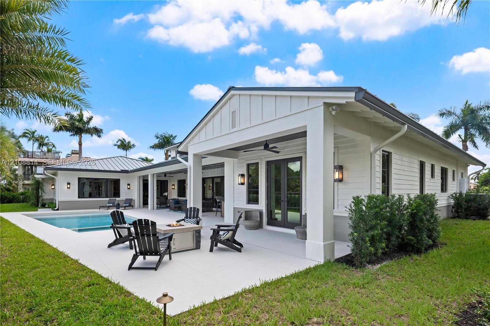 Covered patio featuring board and batten siding, recessed ceiling lighting, attached ceiling fan, and concrete hardscaping surrounding an in-ground sw