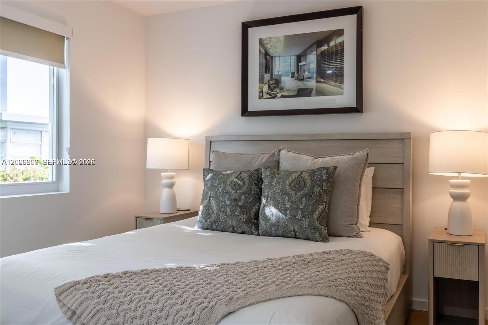 Neutral-toned walls, wood-finish paneling, horizontal window with roller shade, and light-toned built-in cabinetry