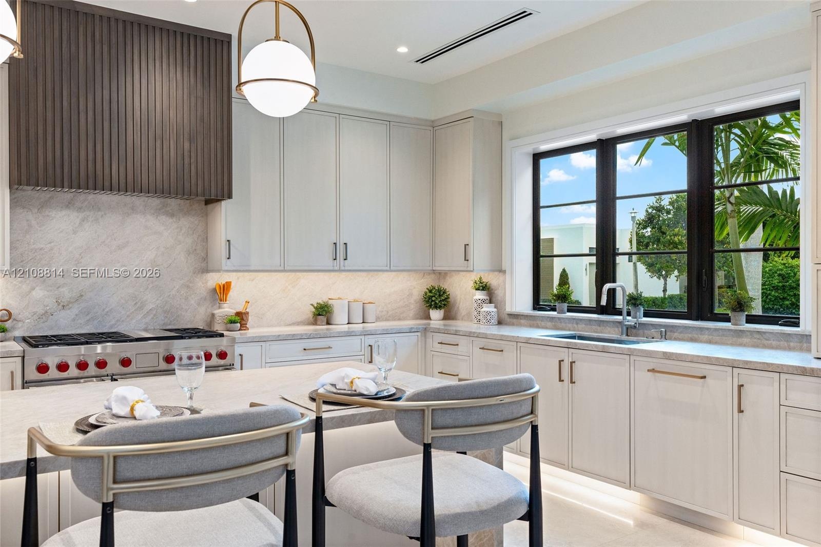 Kitchen featuring flat-panel cabinetry, a stone-surfaced island and countertops, a custom slatted wood range hood, a professional-style gas range, and