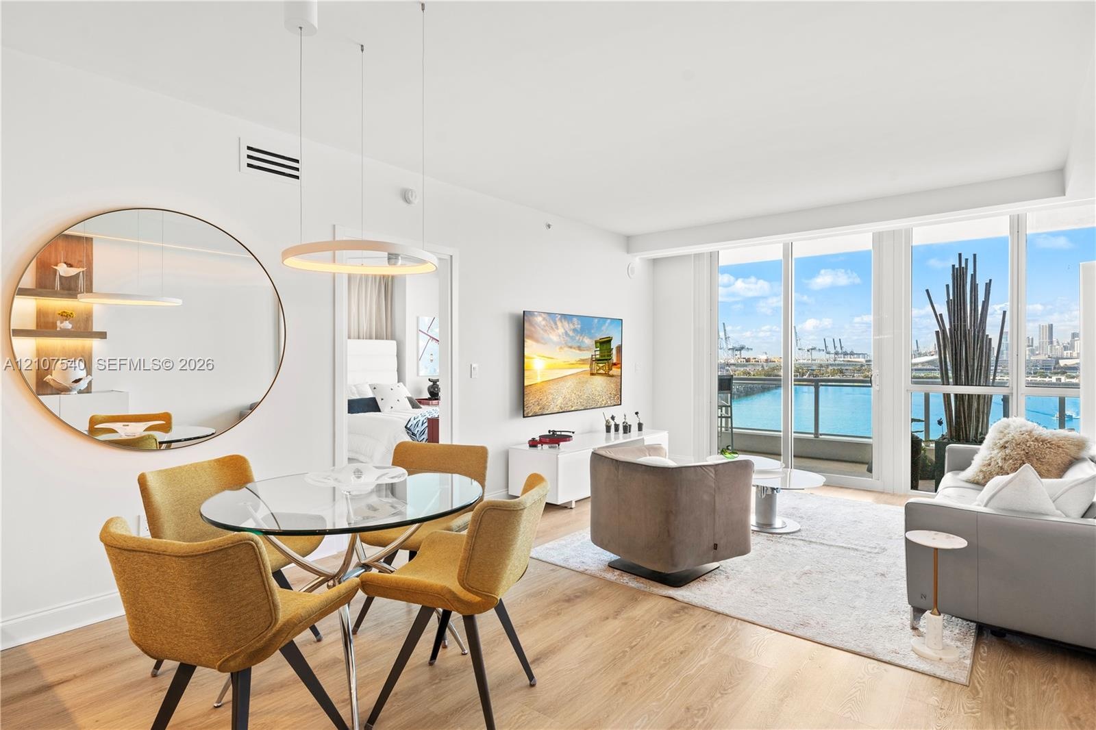 Open-concept professionally remodeled & appointed living space featuring top of the line Porcelanosa wood-finish flooring & floor-to-ceiling windows w