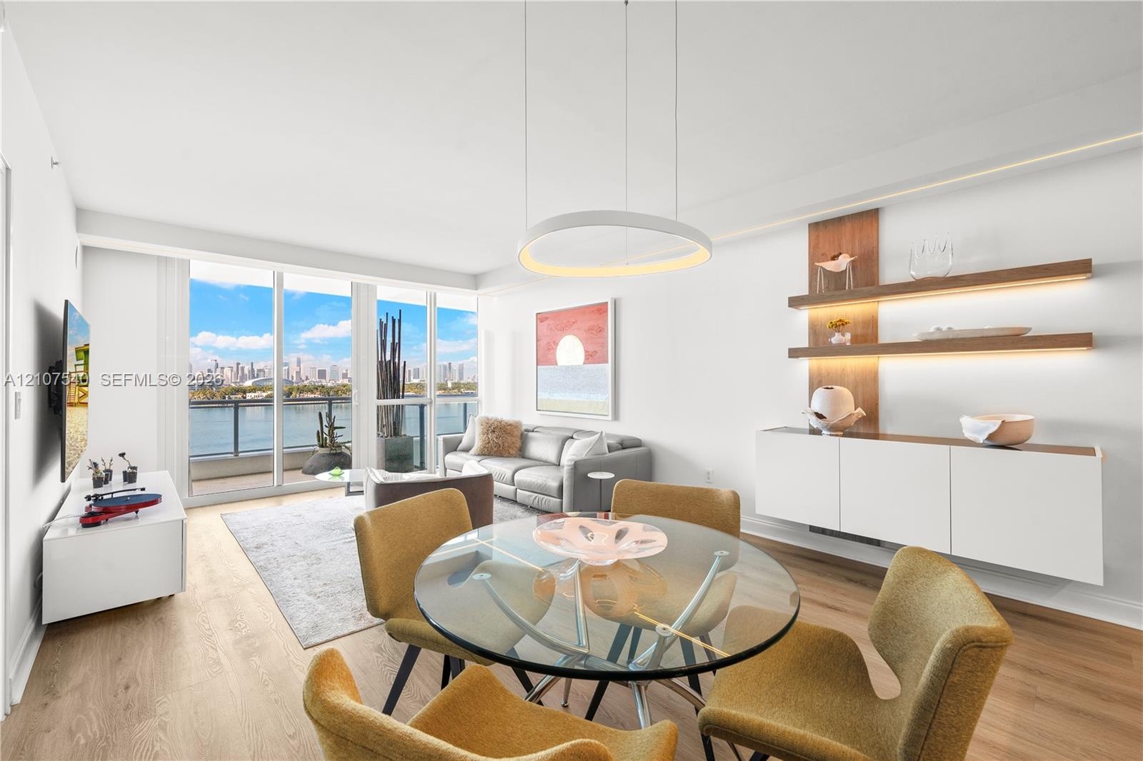 Open-concept living space featuring floor-to-ceiling windows, wood-finish flooring, modern circular LED integrated lighting built into custom soffits,