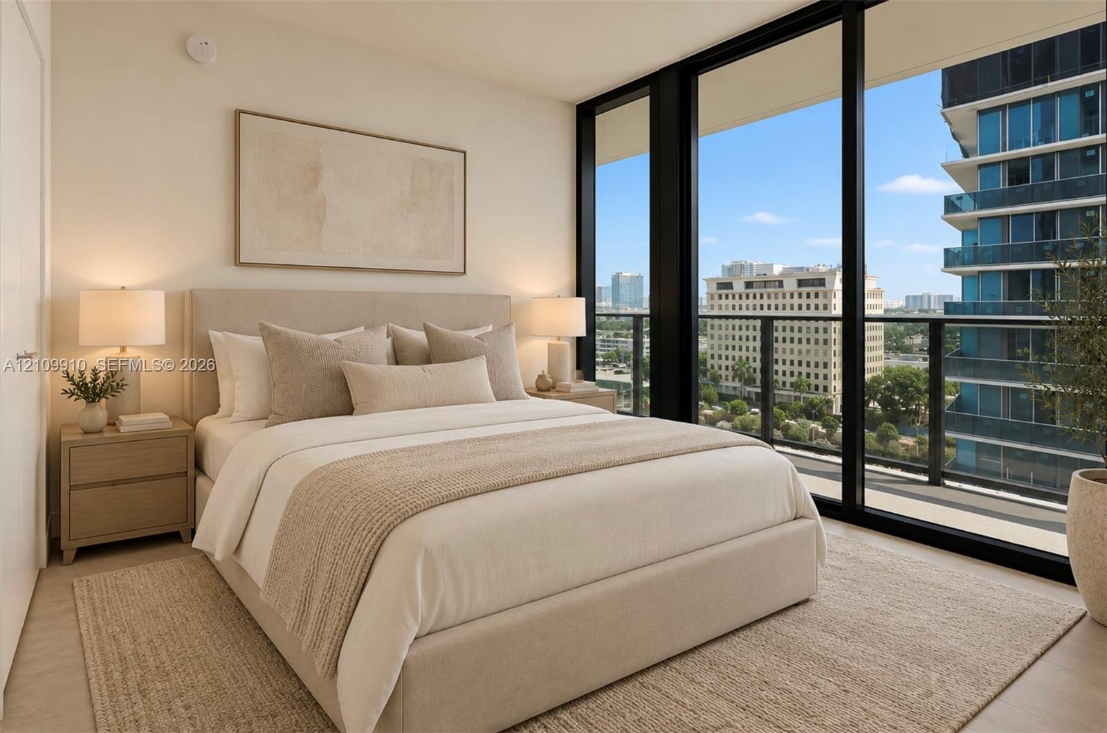 Floor-to-ceiling windows featuring urban scenery and access to an exterior balcony with a metal railing, complemented by neutral-toned interior walls 