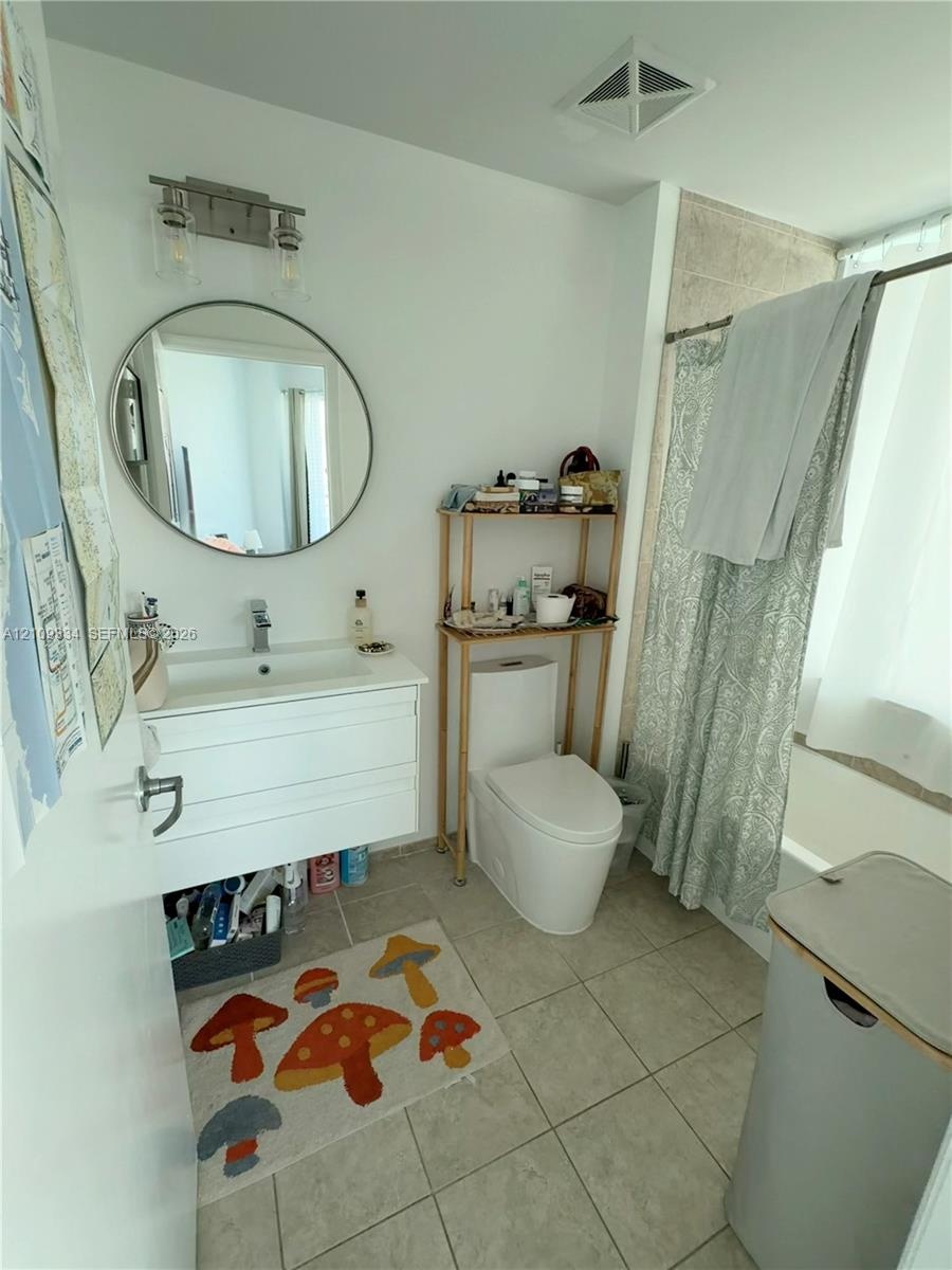 Wall-mounted floating vanity with integrated rectangular sink and polished chrome faucet, circular mirror, modern wall-mounted lighting fixture, and c