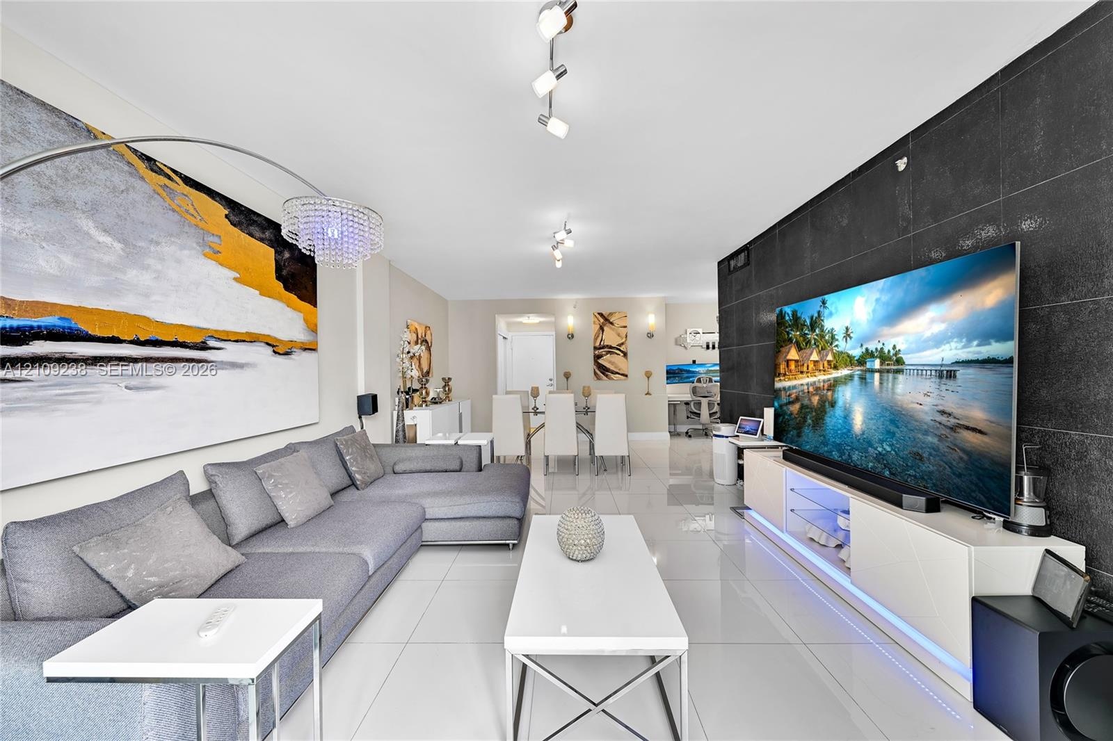 Large format floor tiles, black tiled accent wall, and multi-directional track lighting