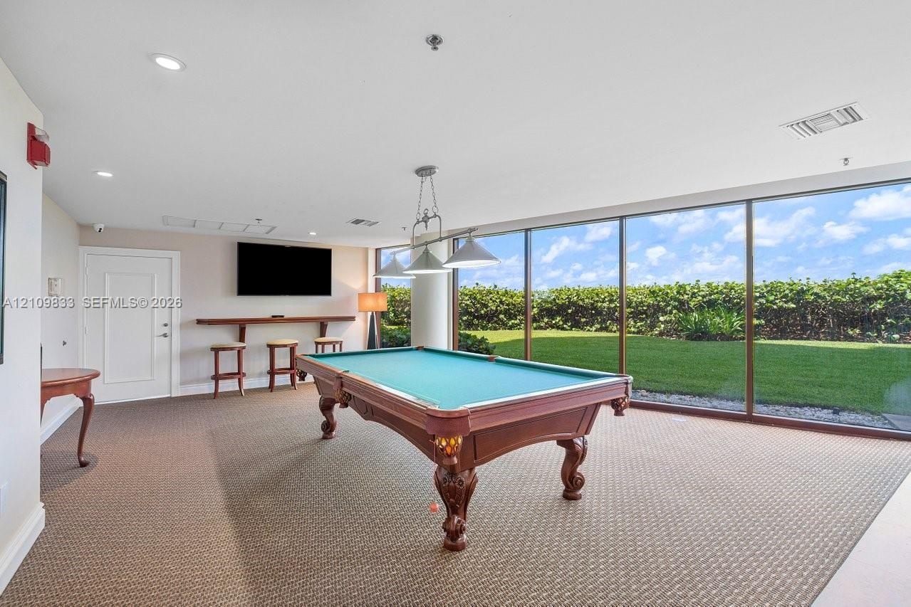 Interior room featuring floor-to-ceiling windows, wall-to-wall carpeting, recessed lighting, and a built-in wooden bar shelf