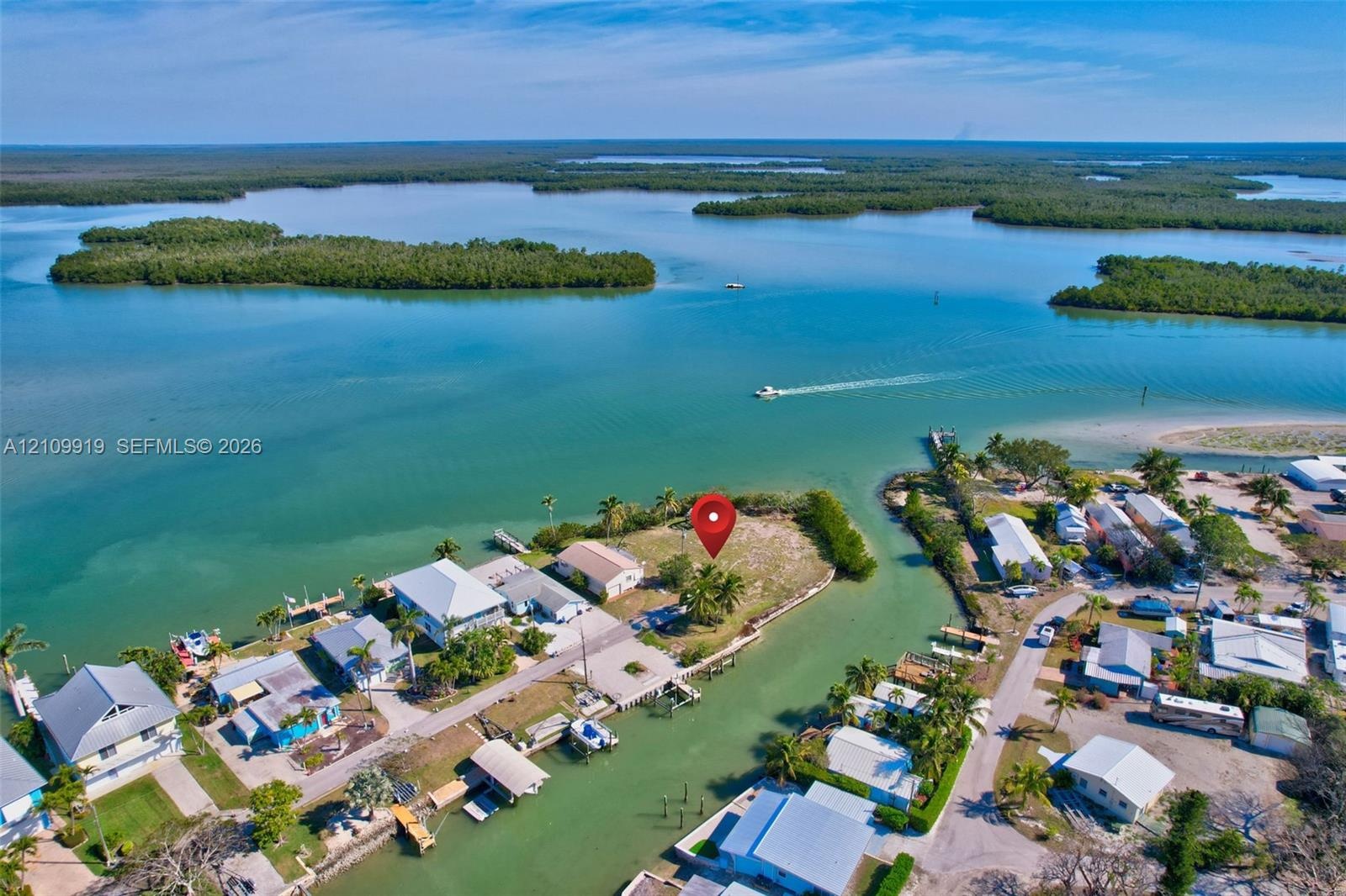 Waterfront parcel situated on a peninsula, featuring direct coastal access and mature palm trees
