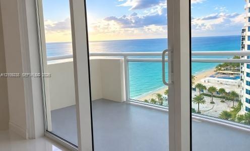 Private balcony featuring glass railings and direct oceanfront scenery