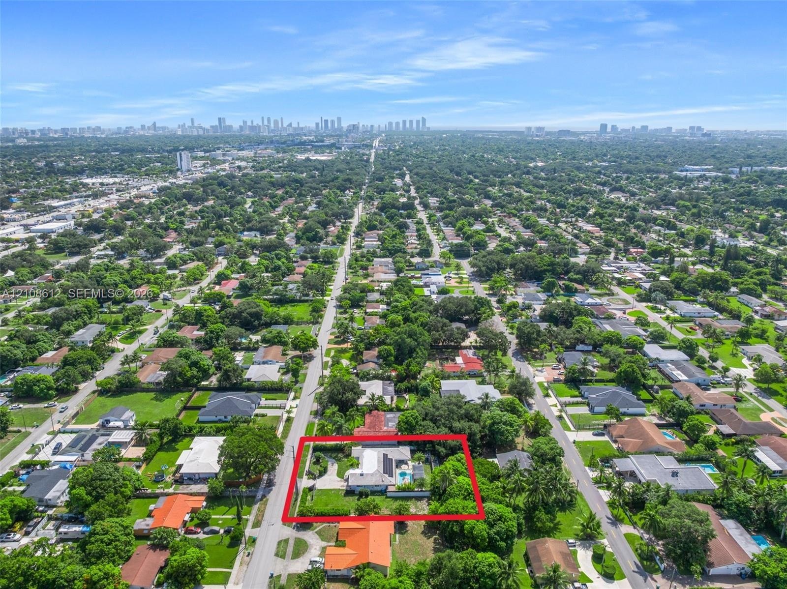 Aerial perspective of a property featuring a swimming pool, expansive lot, and mature landscaping