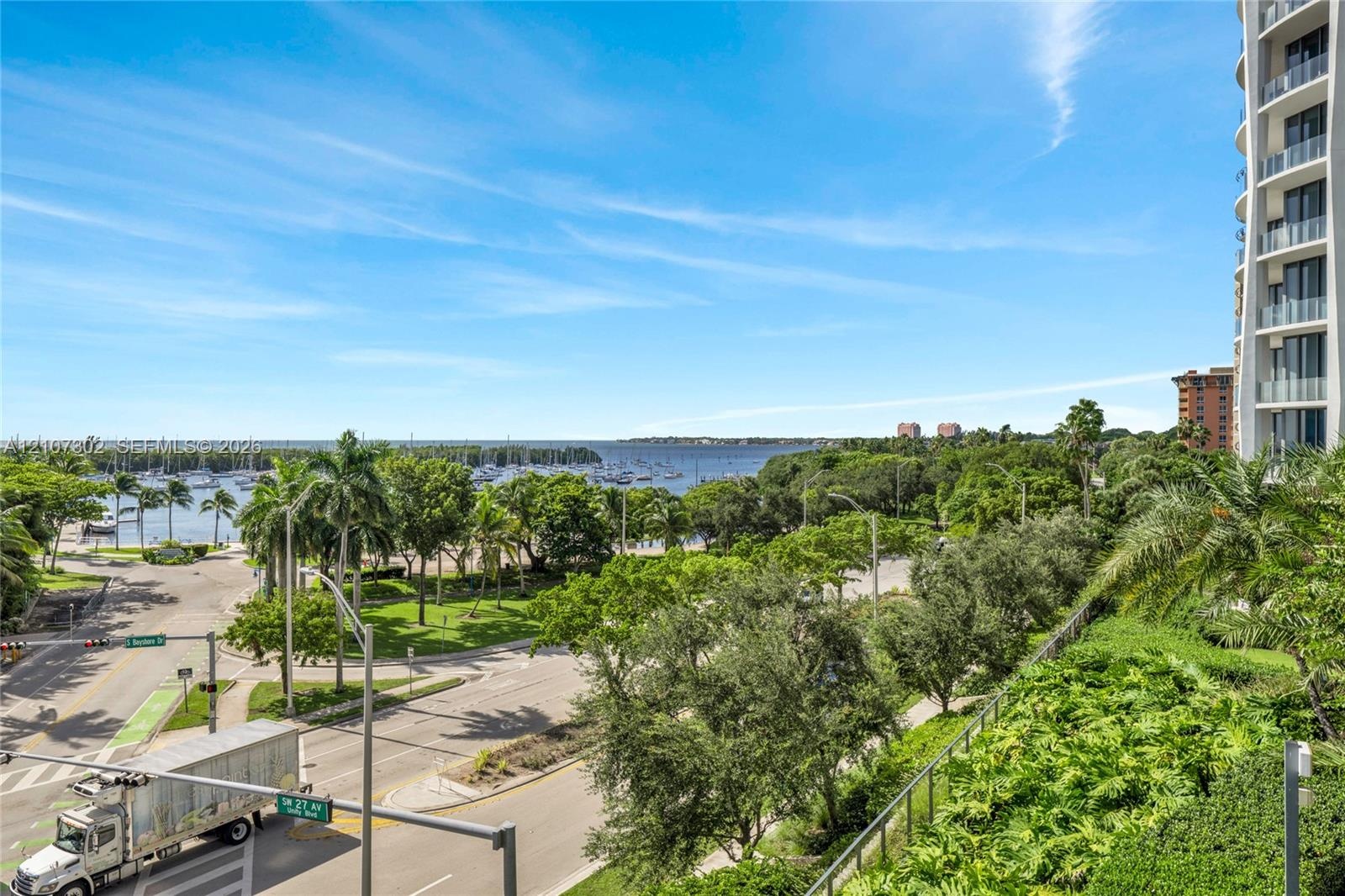 Elevated balcony featuring glass railings, unobstructed waterfront exposure, and expansive coastal landscape
