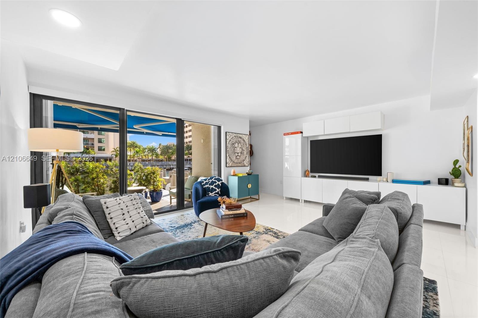 Hallway featuring polished tile flooring, recessed lighting, and a bathroom equipped with a floating vanity, light-toned wood-finish cabinetry, and a 