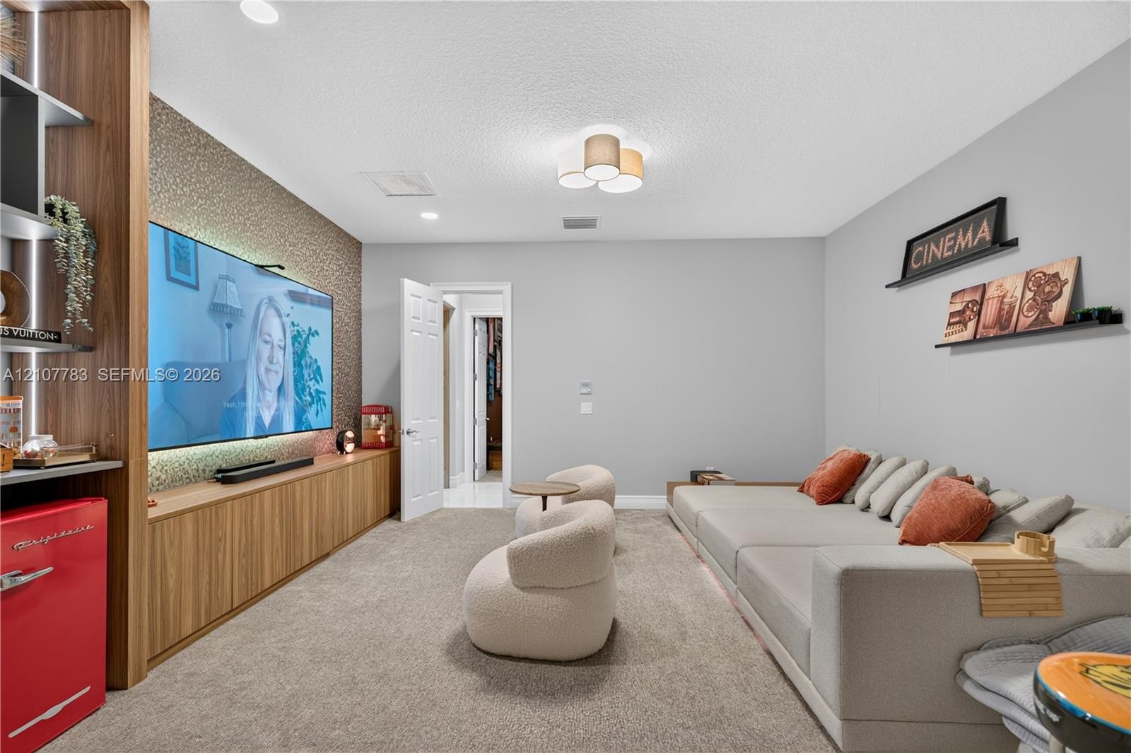 Custom built-in wood-finish cabinetry, textured accent wall, integrated recessed lighting, and flush-mount multi-bulb fixture