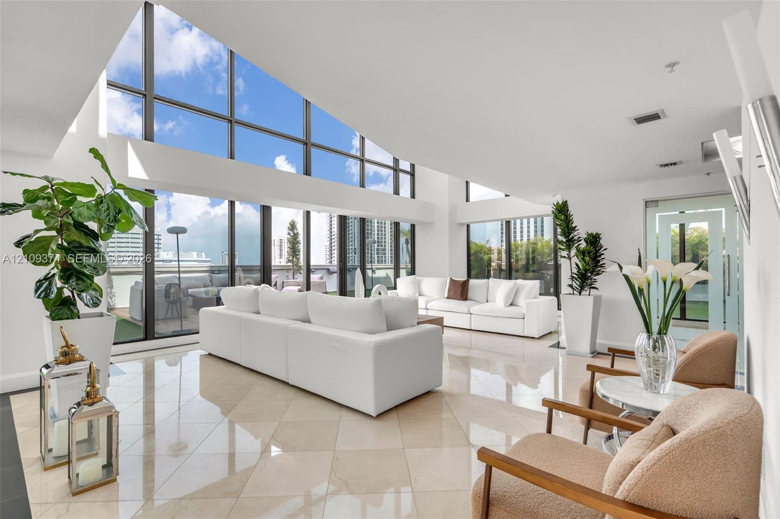 Vaulted ceilings featuring expansive floor-to-ceiling windows and polished stone tile flooring