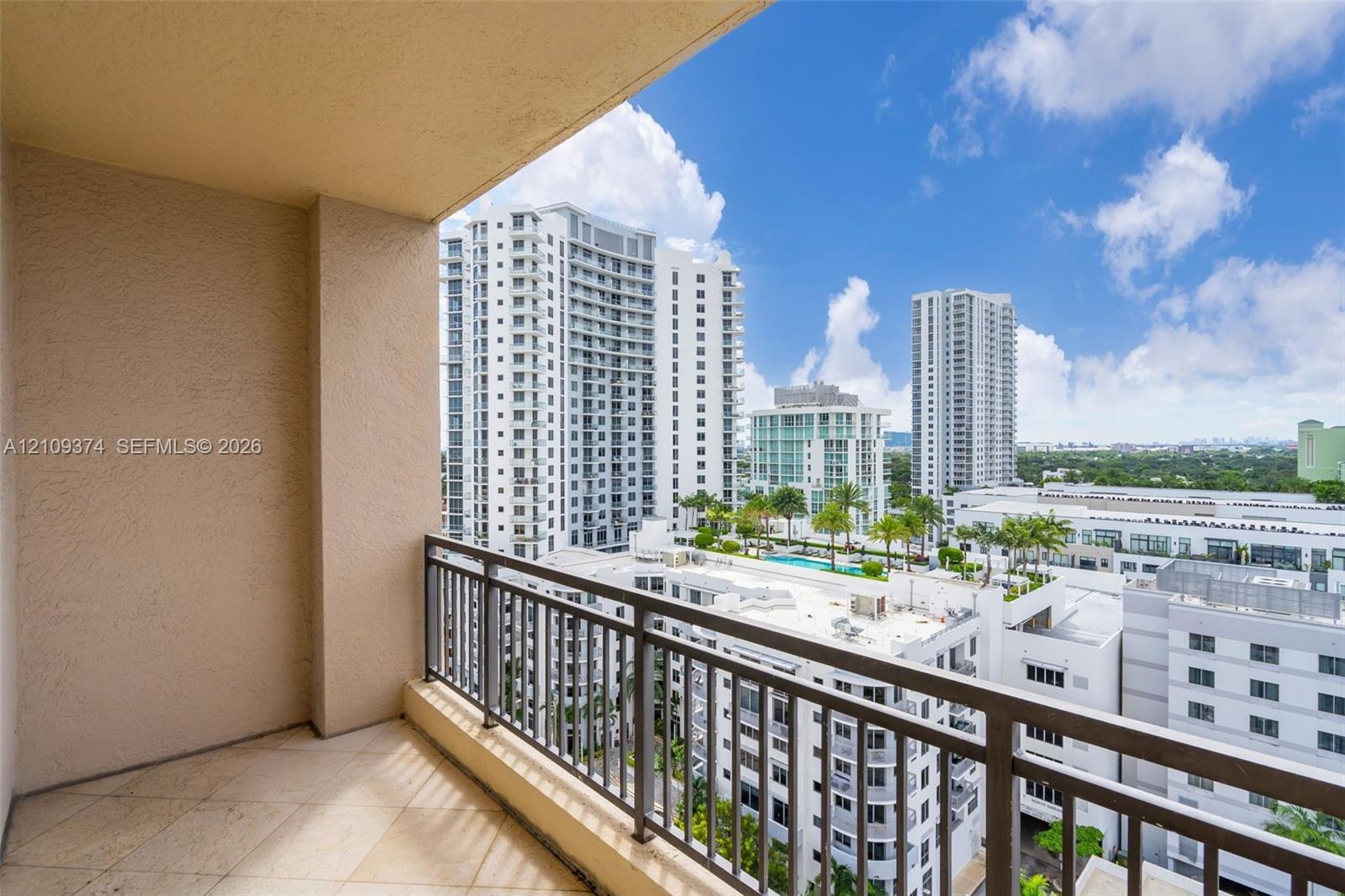 Covered balcony featuring tile flooring and a metal railing