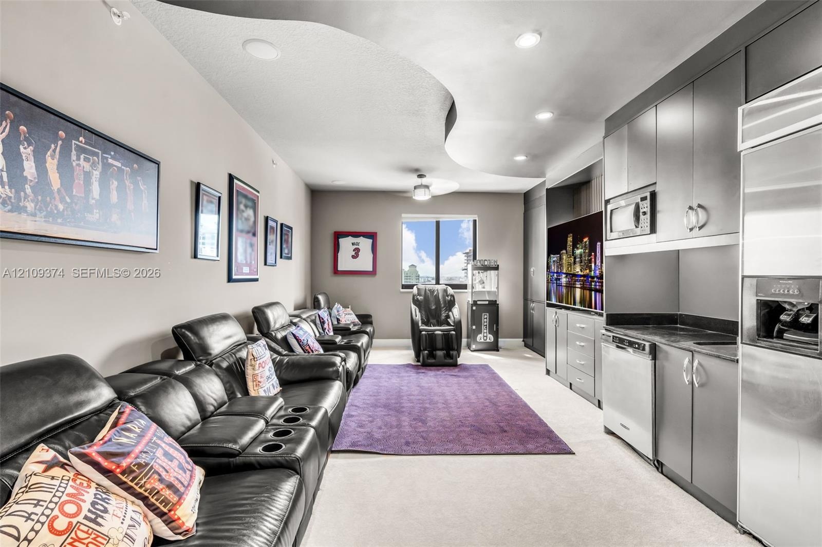 Curved architectural ceiling detail with recessed lighting, integrated cabinetry, stainless steel kitchen appliances, and neutral wall-to-wall carpeti