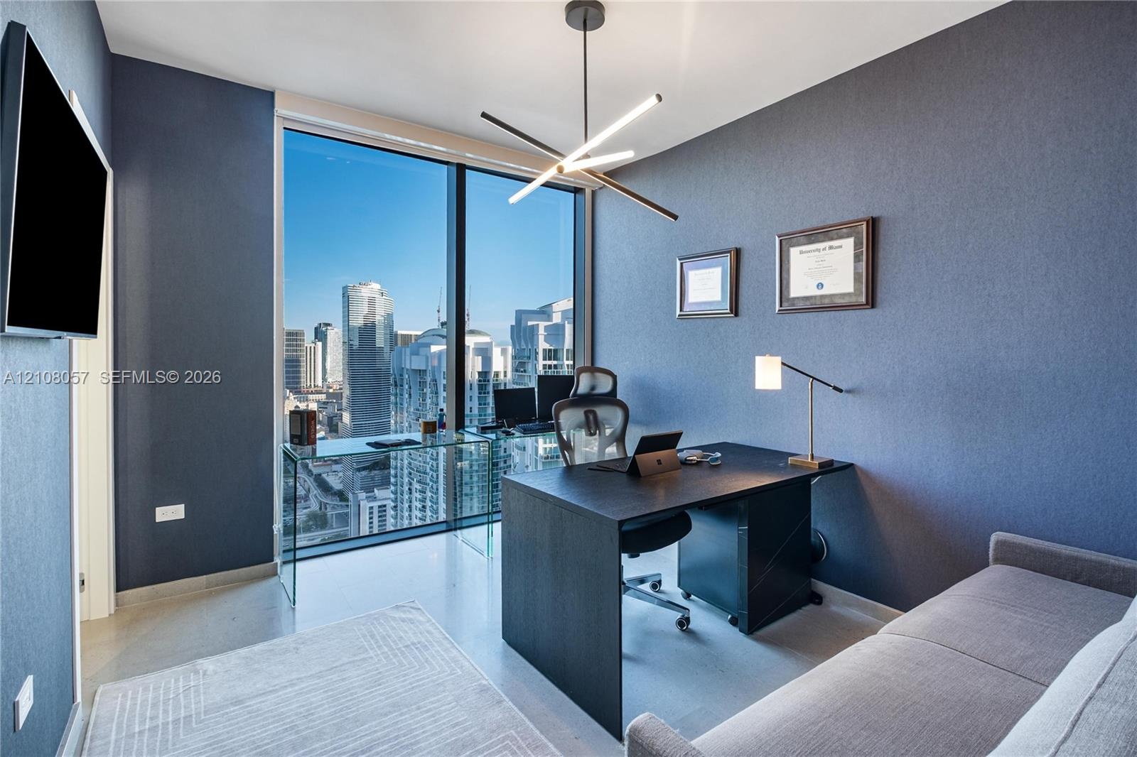 Floor-to-ceiling windows, modern linear chandelier, and neutral wall tones
