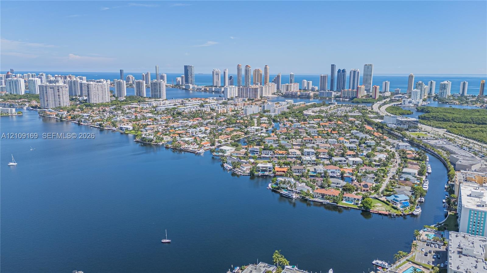 Aerial perspective featuring coastal waterfront location, deep-water access, canal frontage, and skyline silhouette