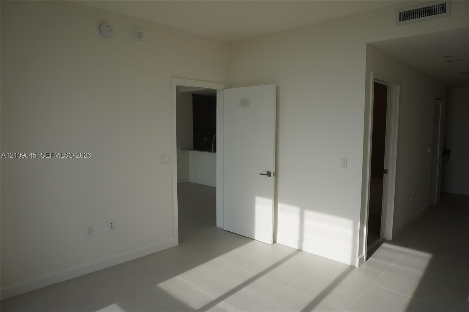 Neutral-toned tile flooring, solid-core interior doors with satin nickel hardware, and recessed ceiling HVAC registers