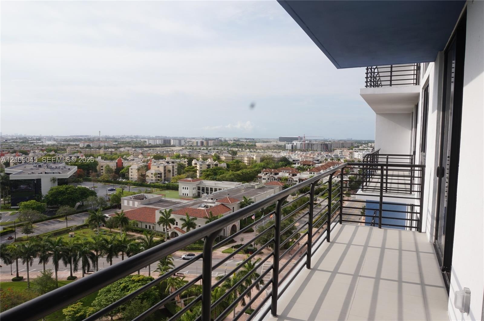 Elevated private balcony featuring metal railing, tiled flooring, and an overhang