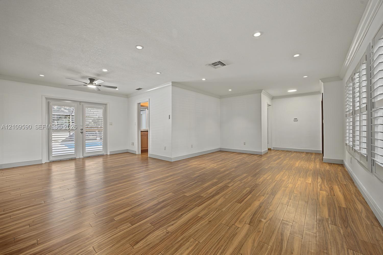 Wood-finish flooring, recessed lighting, ceiling fan, crown molding, and plantation shutters