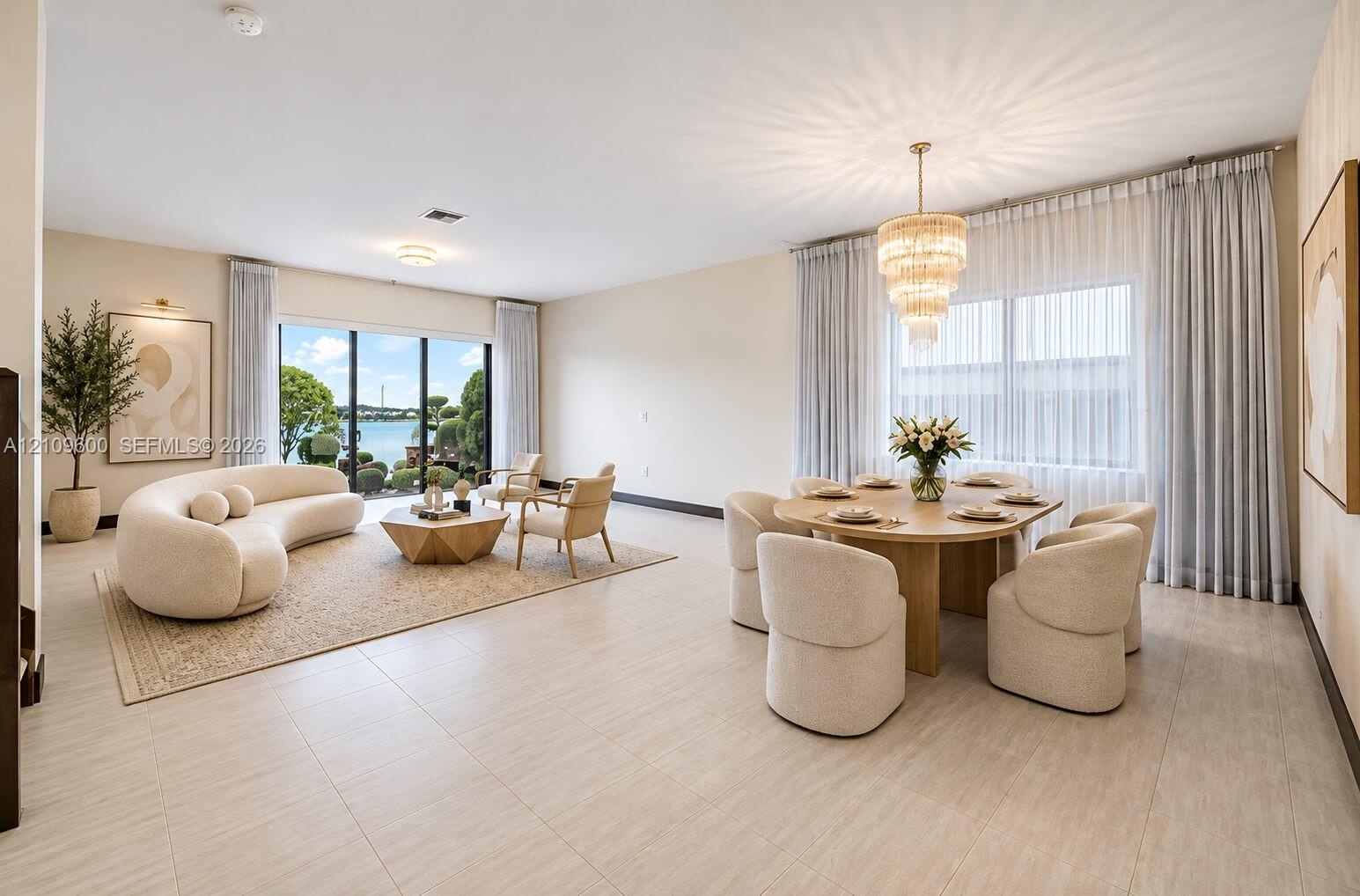Open-concept interior featuring large-format tile flooring, tiered crystal chandelier, and floor-to-ceiling glass sliding doors