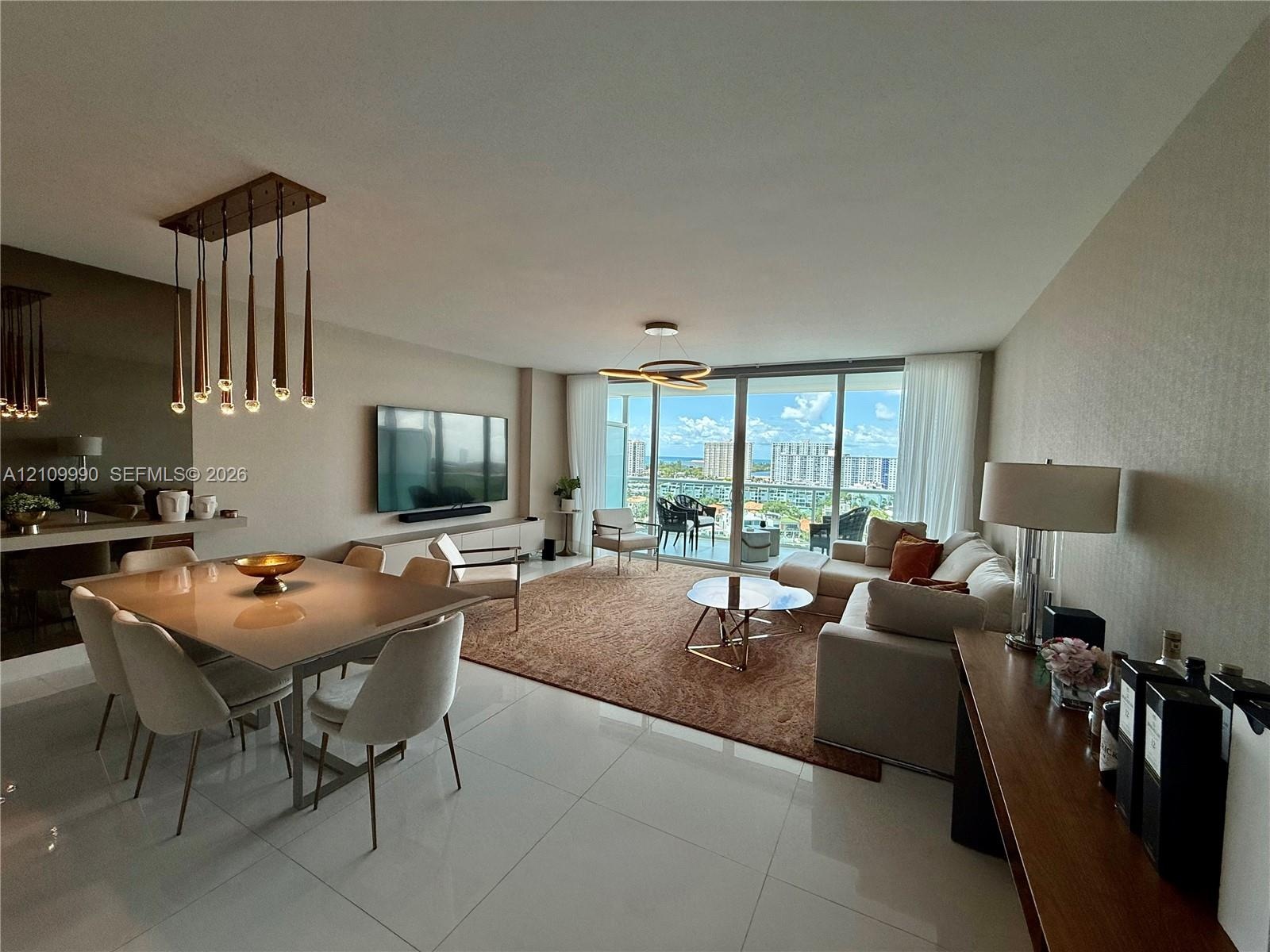 Large-format polished tile flooring, floor-to-ceiling glass sliding doors, modern multi-pendant dining chandelier, and geometric ceiling lighting fixt