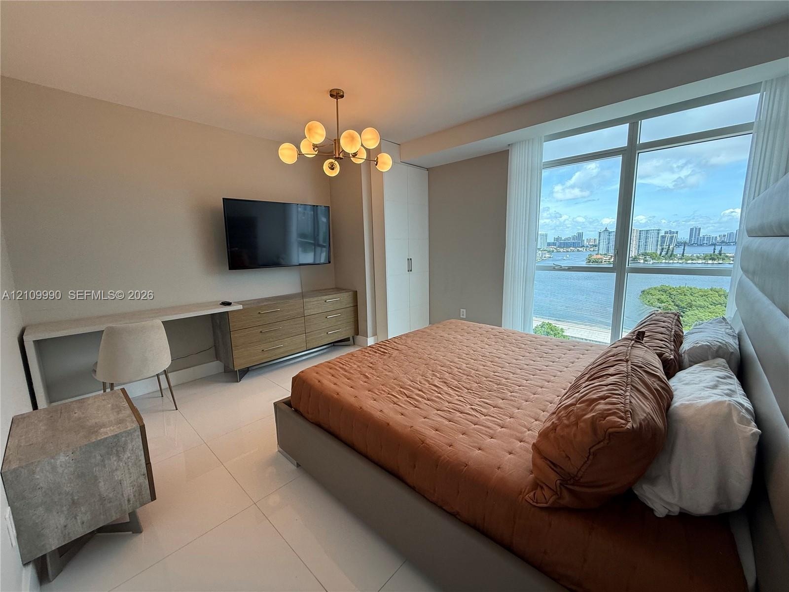 Floor-to-ceiling windows, polished tile flooring, multi-globe chandelier, and built-in cabinetry