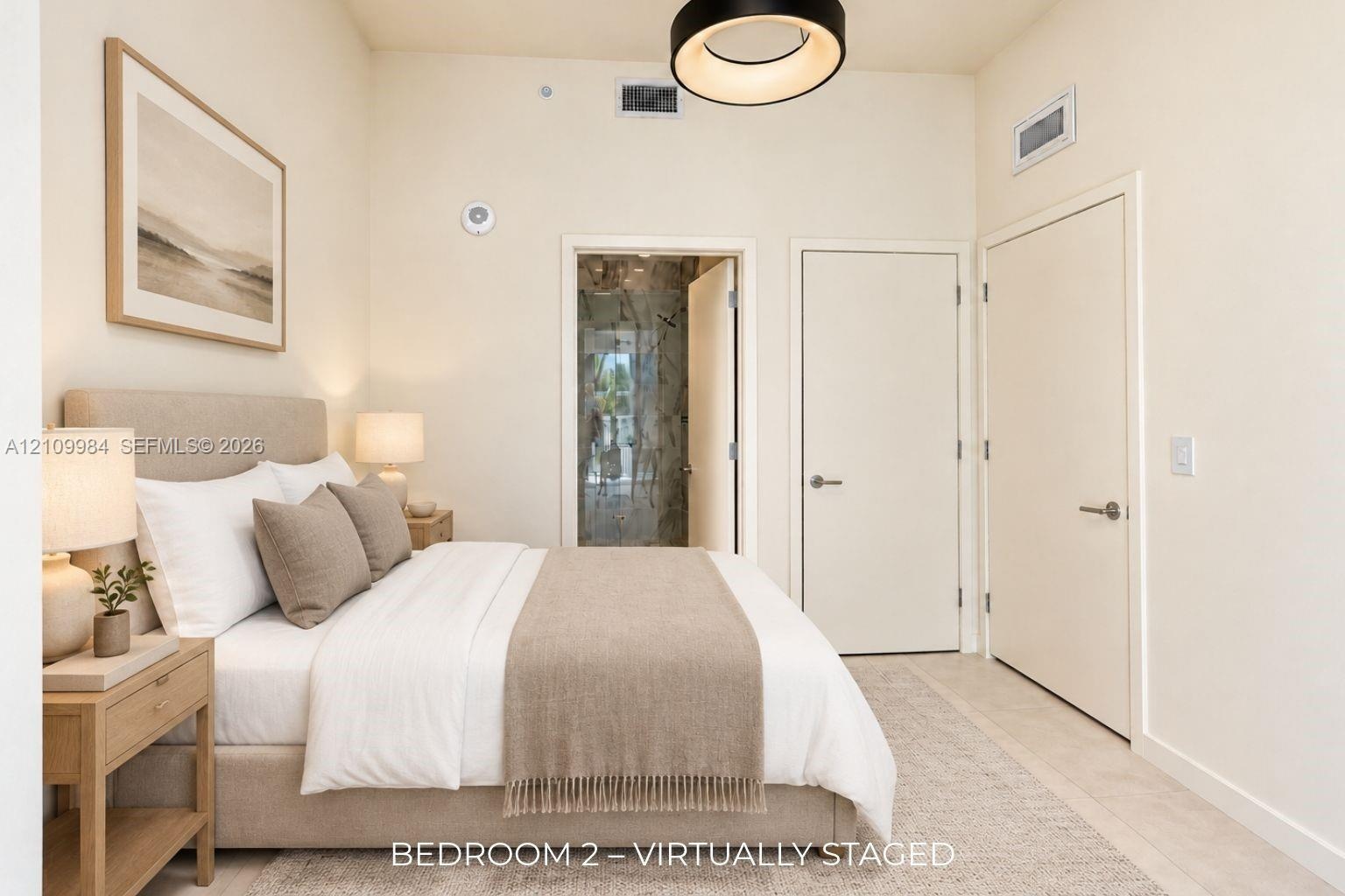 Neutral-toned room featuring high ceilings, a contemporary circular pendant light fixture, and solid-core interior doors with satin nickel hardware