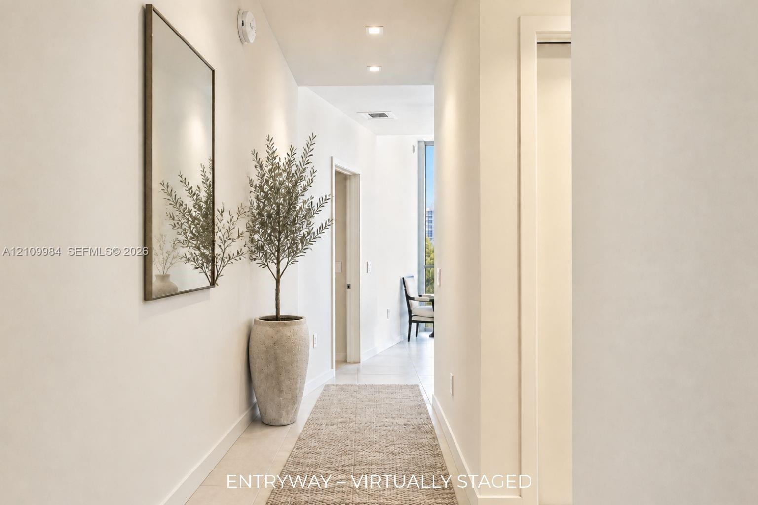 Hallway featuring recessed ceiling lighting, light-toned flooring, and neutral wall finishes