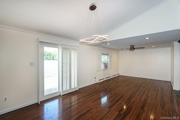 Spare room with ornamental molding, plenty of natural light, dark wood-style floors, a baseboard radiator, and recessed lighting