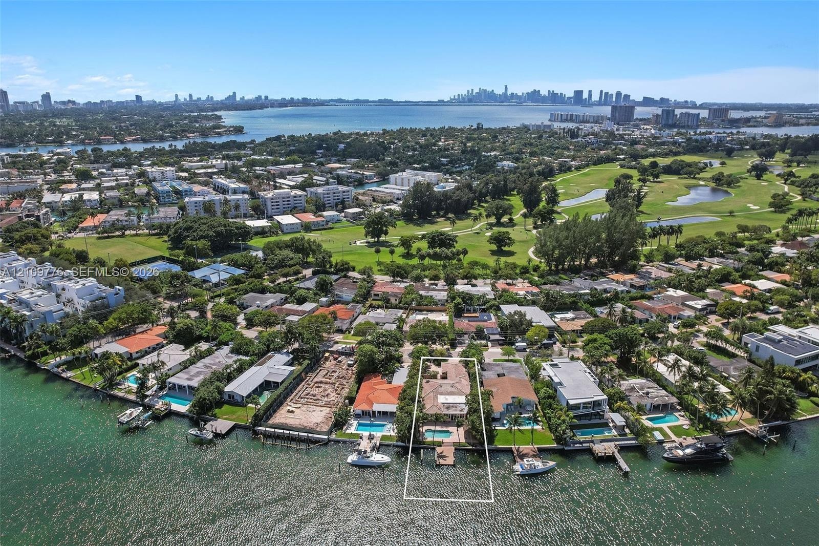 Waterfront property featuring a private boat dock, swimming pool, and direct shoreline access