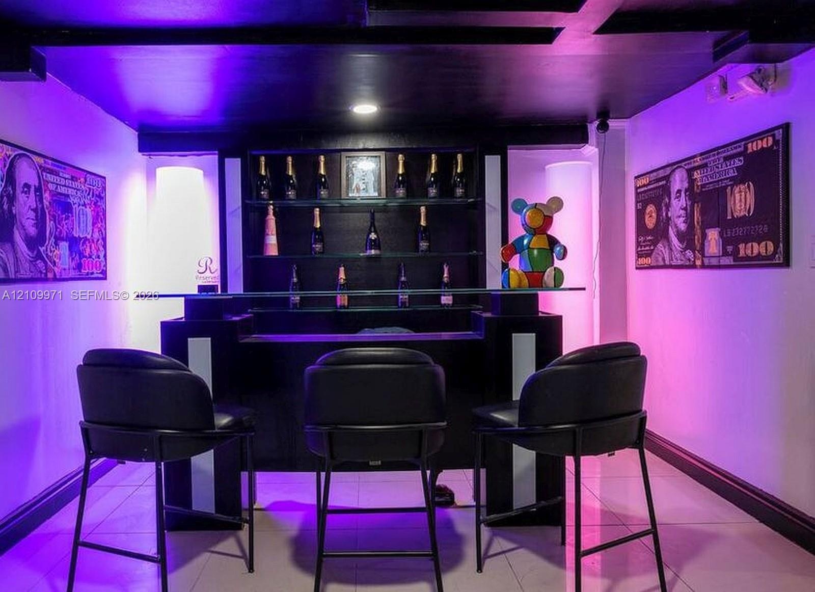 Built-in wet bar featuring multi-level open shelving and a glass countertop