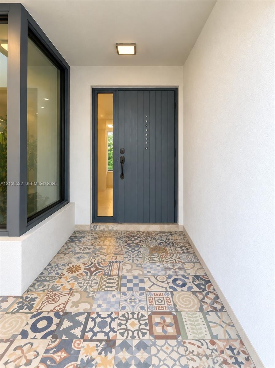 Entryway featuring patterned encaustic-style floor tile.