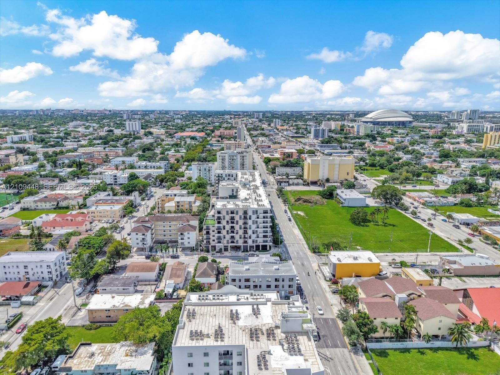 Aerial perspective of a multi-story urban residential building featuring a flat roof with exterior mechanical units and a grid of private balconies