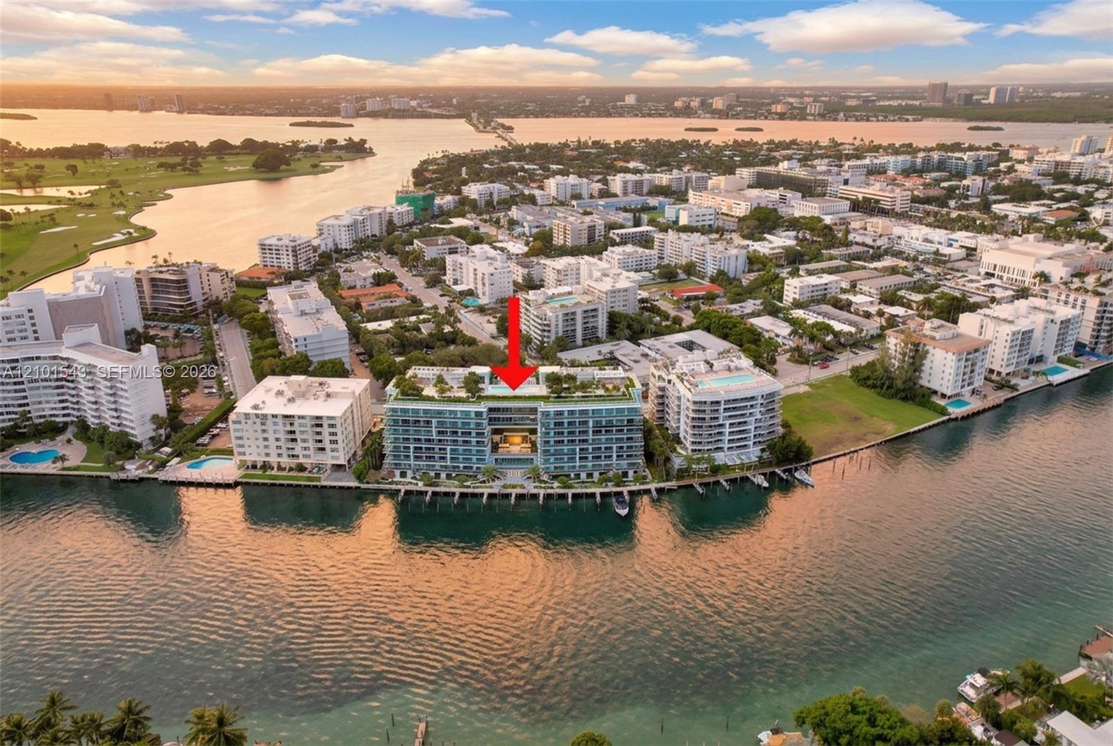 Waterfront mid-rise building featuring a rooftop pool, expansive balcony terraces, and direct canal access