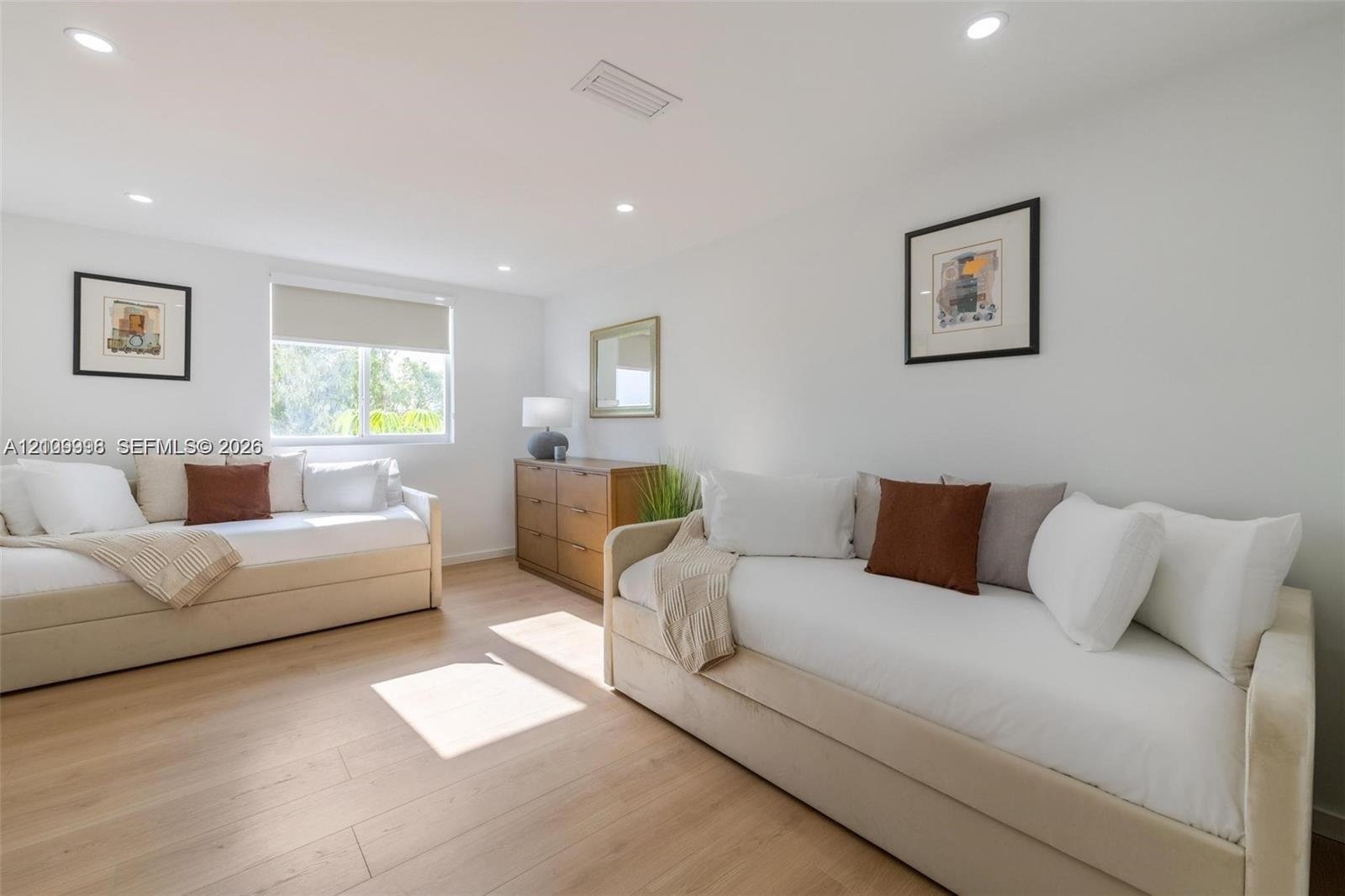 Interior space featuring wood-finish flooring, recessed lighting, and a single-pane window with a roller shade