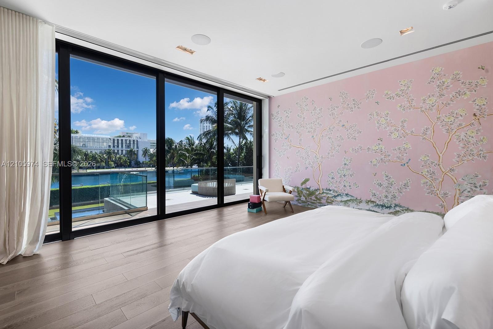 Floor-to-ceiling glass sliding doors, wood-finish flooring, recessed ceiling lighting, and custom floral-motif wall covering