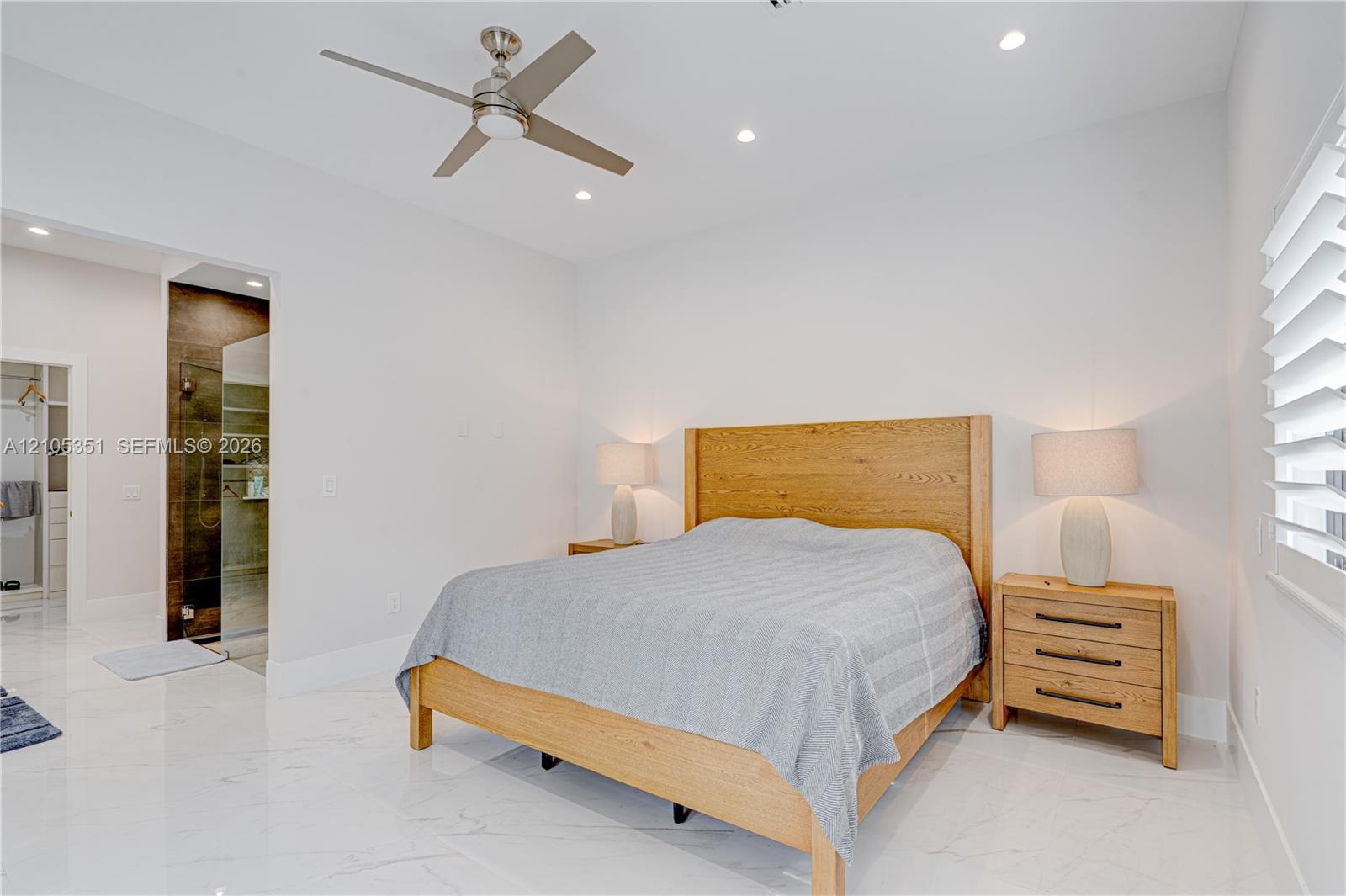 High-gloss stone-finish flooring, recessed ceiling lighting, brushed-nickel ceiling fan, and white shutter window treatments