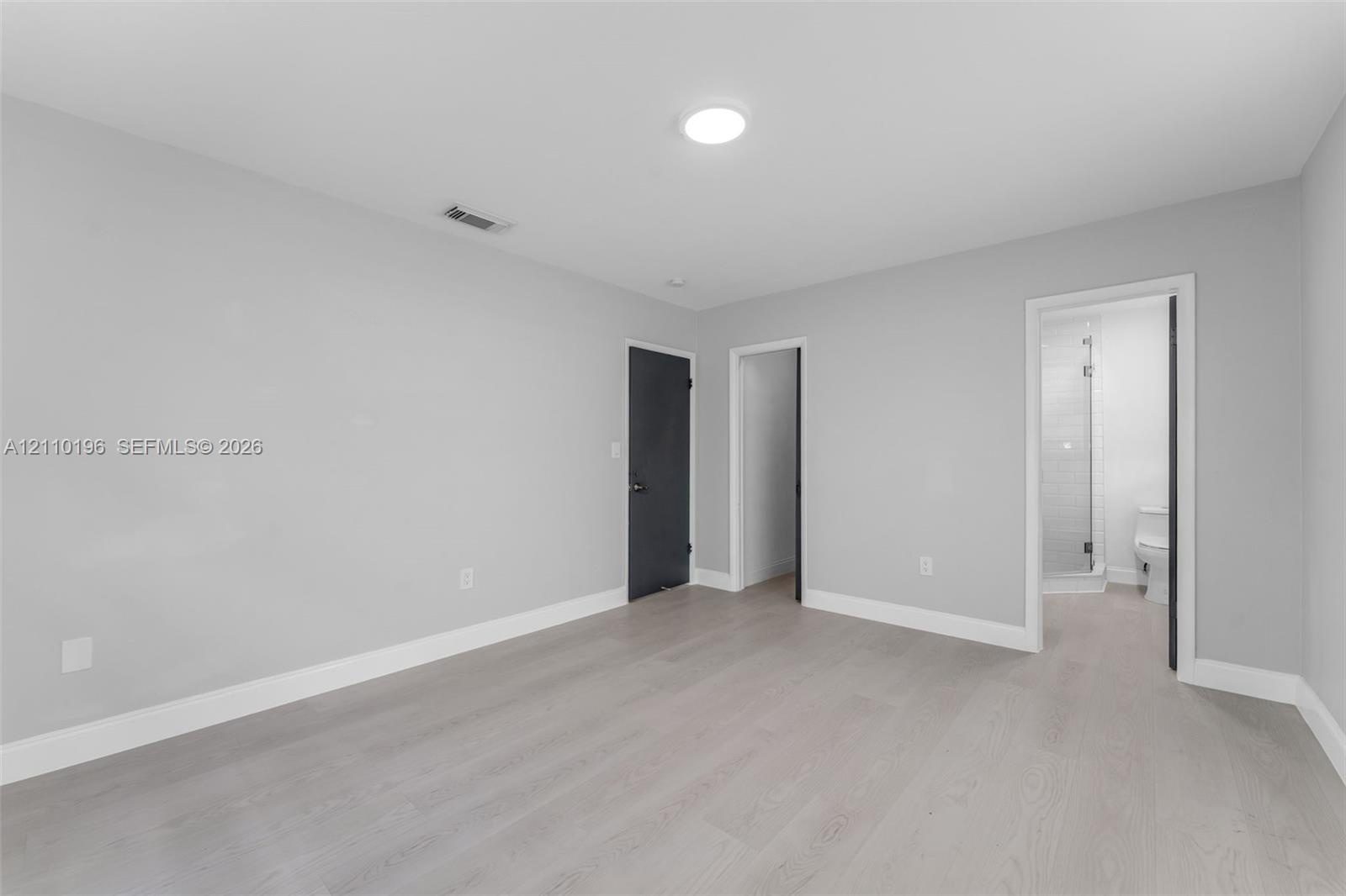 Neutral interior space featuring wood-finish flooring, recessed lighting, and solid-core doors