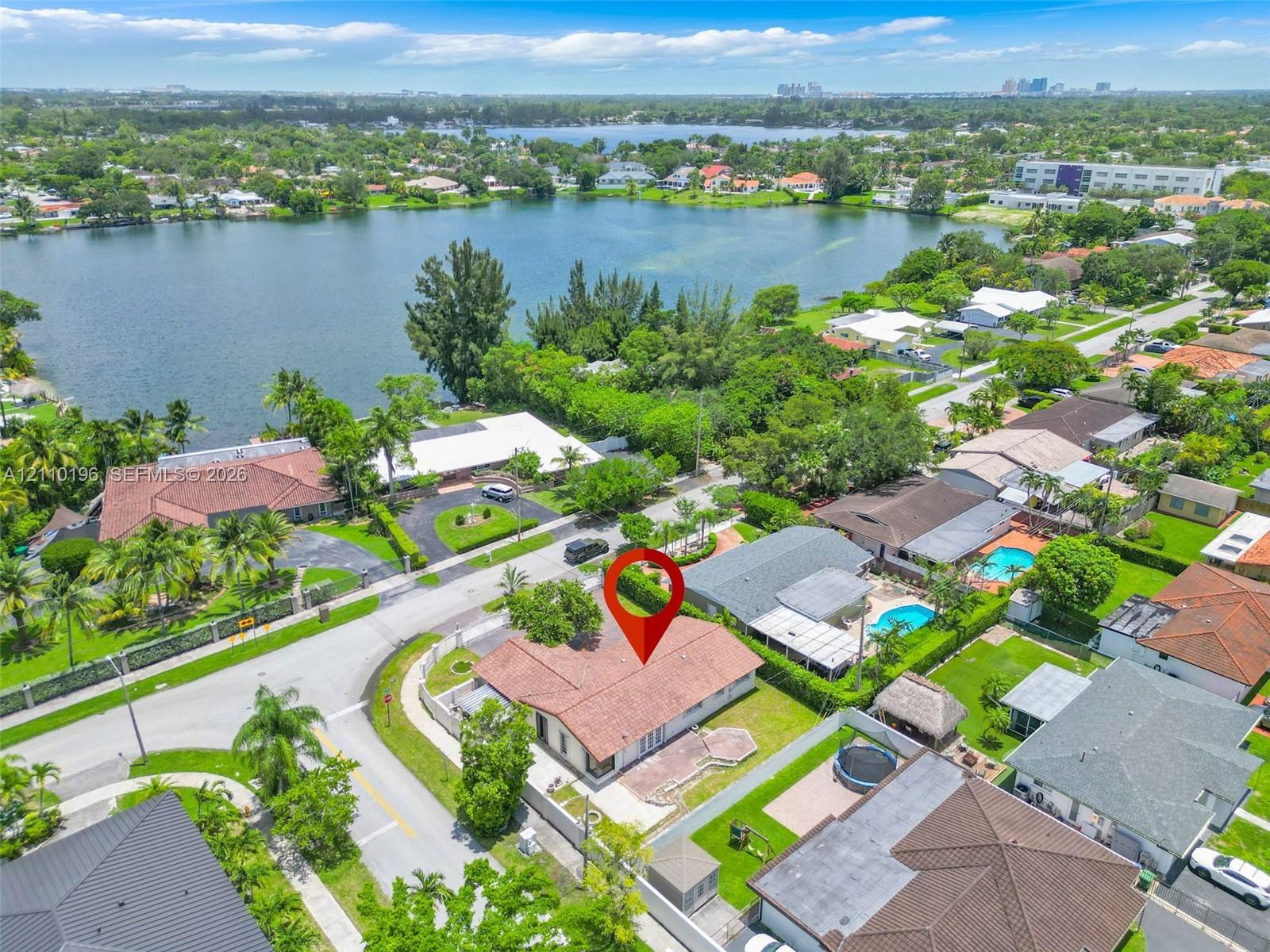 Aerial perspective featuring a shingle-style roof, corner lot placement, and proximity to a lakefront